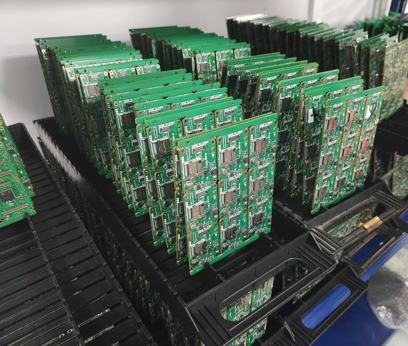 Assembled PCBA panels organized in production racks