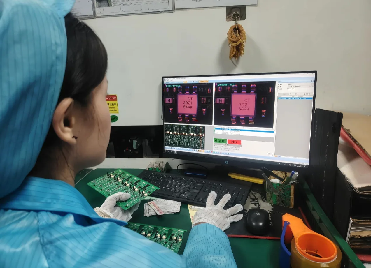 Operator reviewing an assembled board at an AOI inspection workstation
