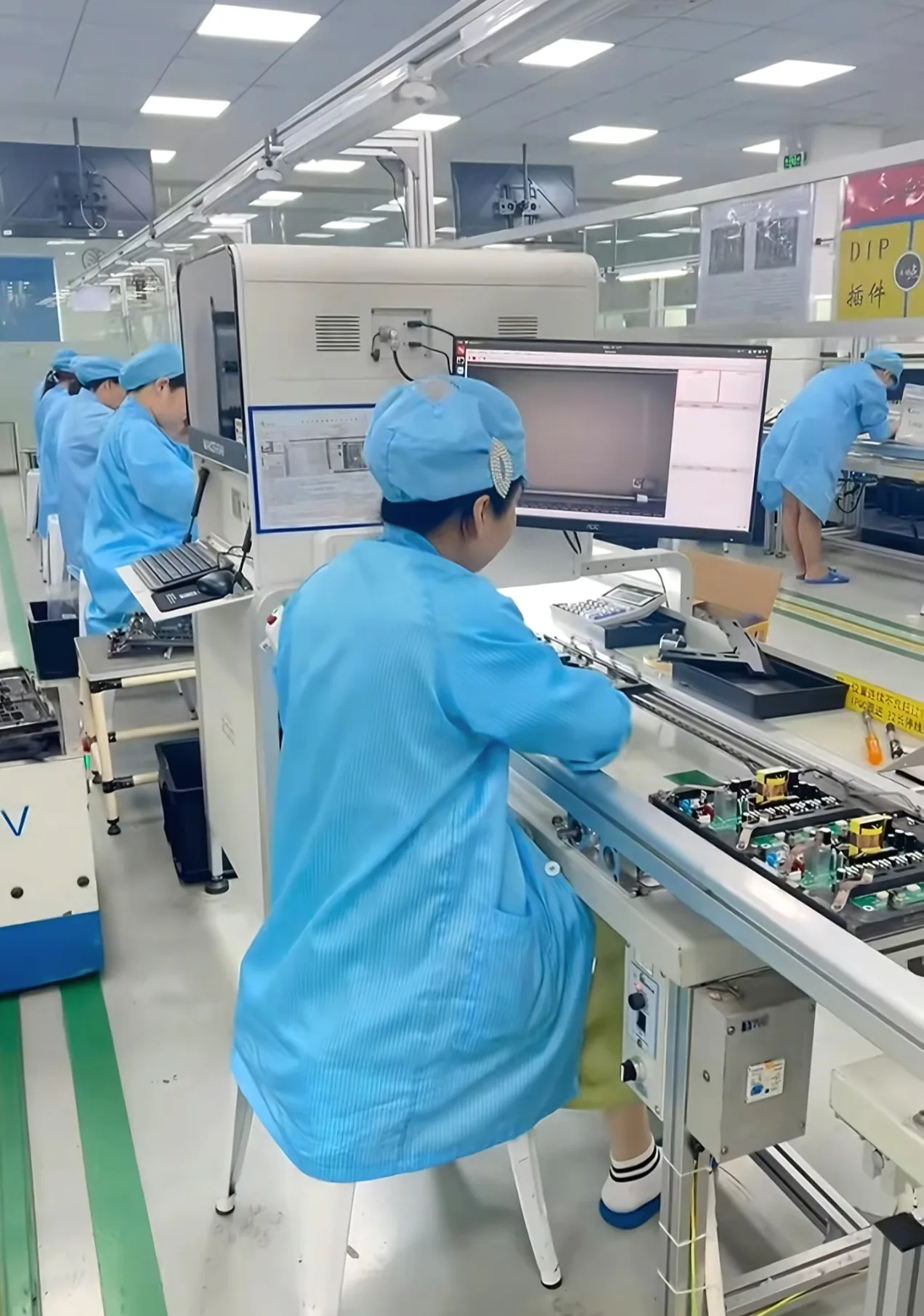 Operator inspecting PCBA assemblies on a production line