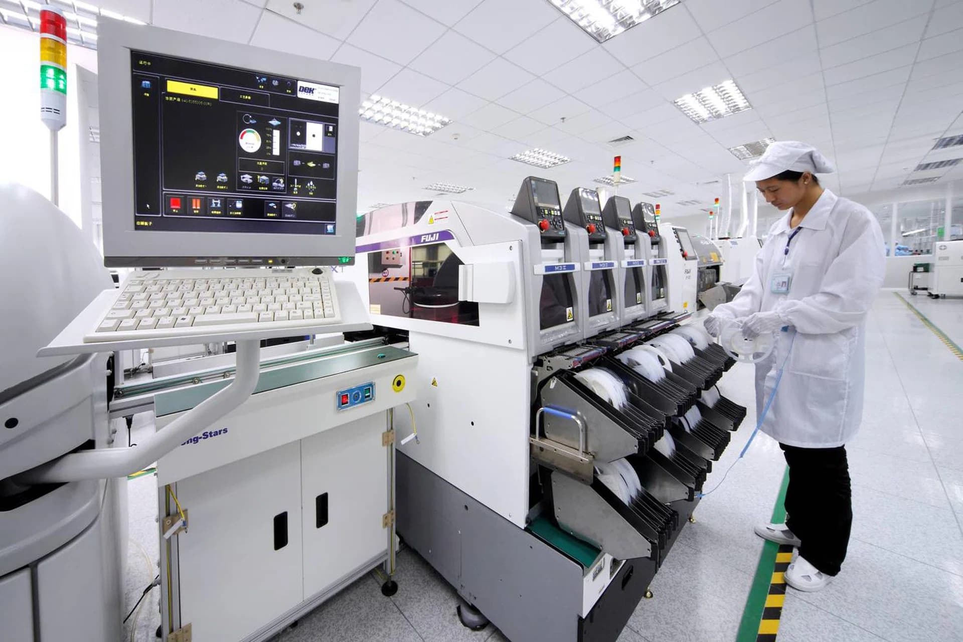 Technician working beside SMT placement equipment